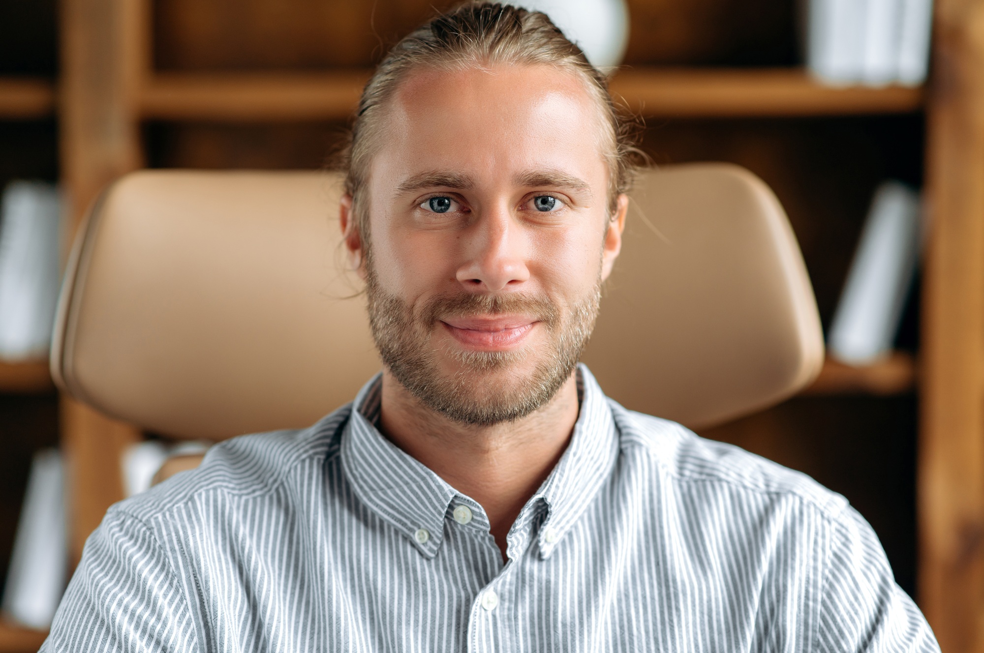 Close-up headshot of attractive positive successful young caucasian man, smiling friendly